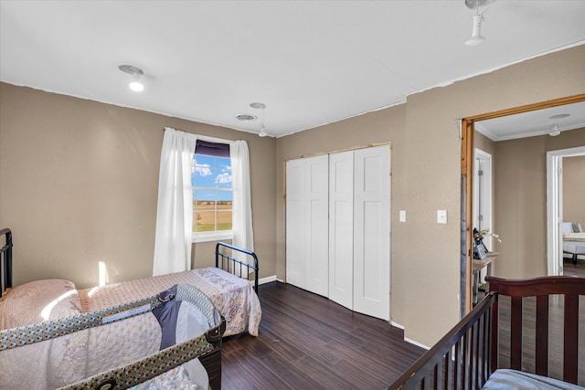 bedroom with dark hardwood / wood-style flooring, a closet, and crown molding