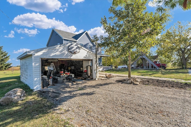 view of side of home with a lawn and an outdoor structure