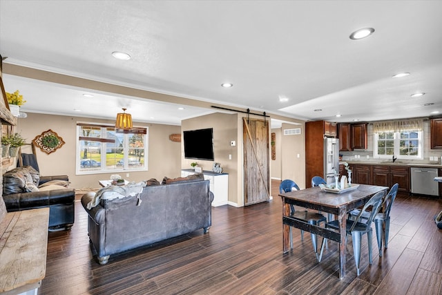 dining room featuring ornamental molding, dark hardwood / wood-style flooring, and a barn door