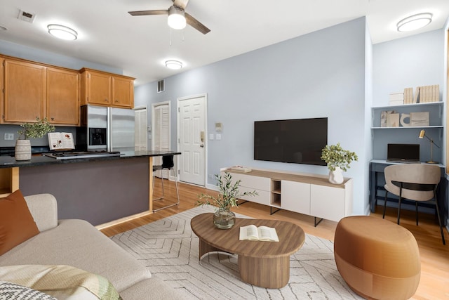 living room with ceiling fan and light wood-type flooring