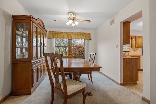 carpeted dining area featuring ceiling fan