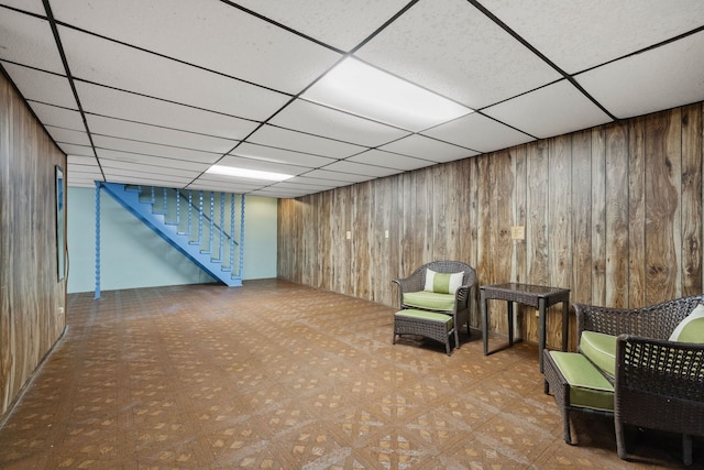 unfurnished room with a paneled ceiling and wood walls