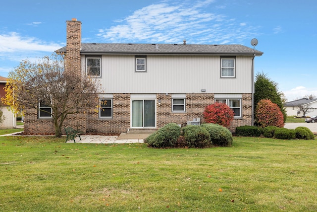 back of house featuring a lawn and a patio area