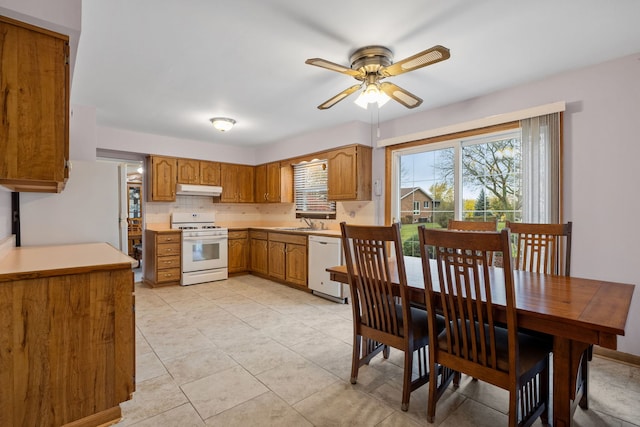 kitchen with white appliances, sink, ceiling fan, decorative backsplash, and light tile patterned flooring