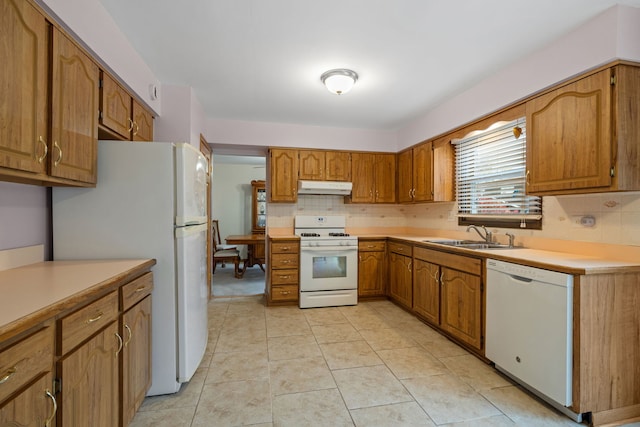 kitchen with decorative backsplash, light tile patterned flooring, white appliances, and sink