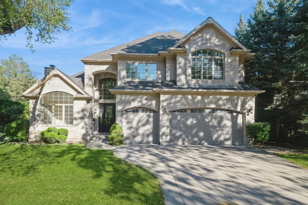 view of front of house with a garage and a front lawn