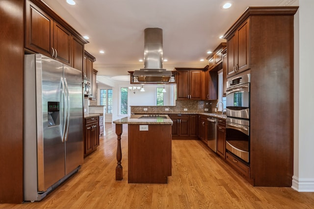 kitchen featuring light wood-type flooring, a center island, a kitchen bar, and stainless steel appliances