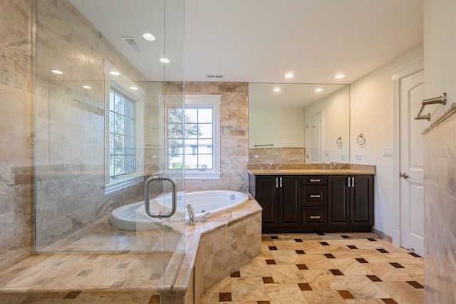 bathroom with vanity and tiled tub