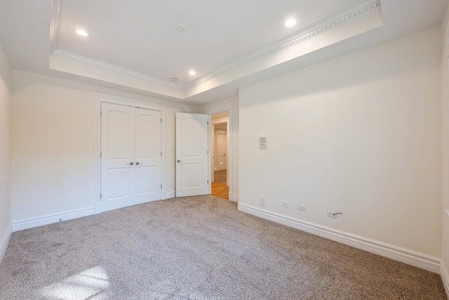 unfurnished bedroom with crown molding, carpet floors, and a raised ceiling