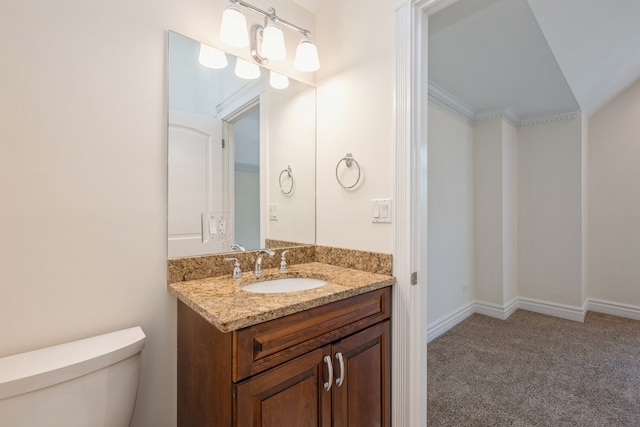 bathroom featuring ornamental molding, vanity, and toilet