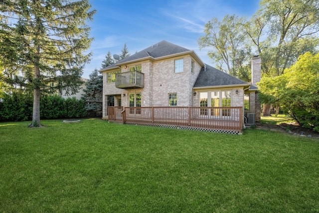 back of house with a yard and a balcony