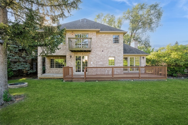 back of property featuring a balcony and a yard