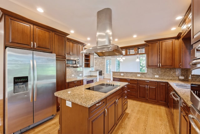 kitchen with decorative backsplash, light hardwood / wood-style flooring, island exhaust hood, a kitchen island, and appliances with stainless steel finishes