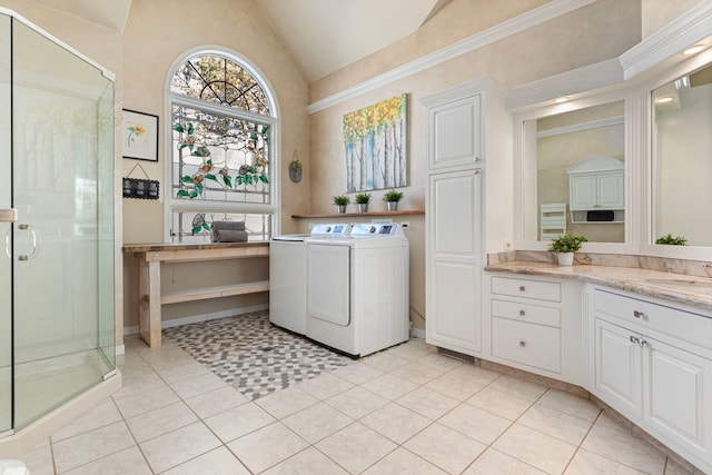 laundry area with a high ceiling, light tile patterned flooring, washer and clothes dryer, and sink