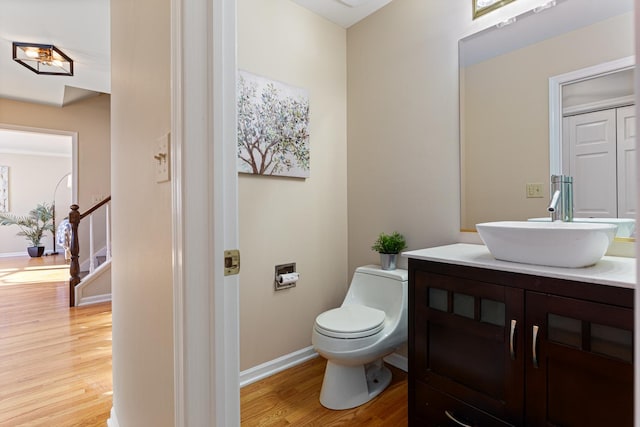 bathroom with toilet, hardwood / wood-style flooring, and vanity