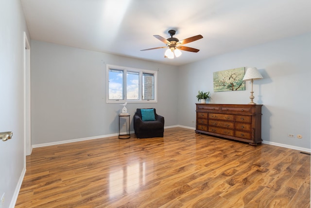 living area featuring hardwood / wood-style flooring and ceiling fan