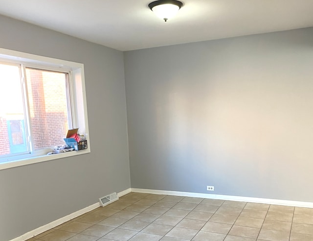 spare room with light tile patterned flooring and a healthy amount of sunlight