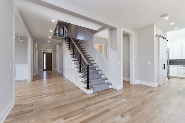 foyer featuring a barn door and light wood-type flooring