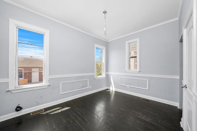 unfurnished room featuring a healthy amount of sunlight, dark hardwood / wood-style flooring, and ornamental molding