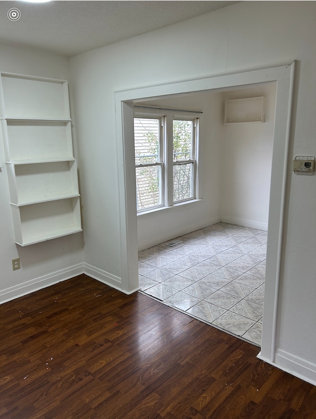 spare room with a textured ceiling and hardwood / wood-style flooring