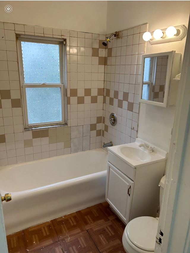 full bathroom with vanity, parquet floors, toilet, and tiled shower / bath