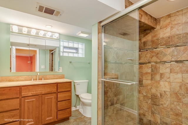 bathroom with tile patterned floors, vanity, toilet, and walk in shower