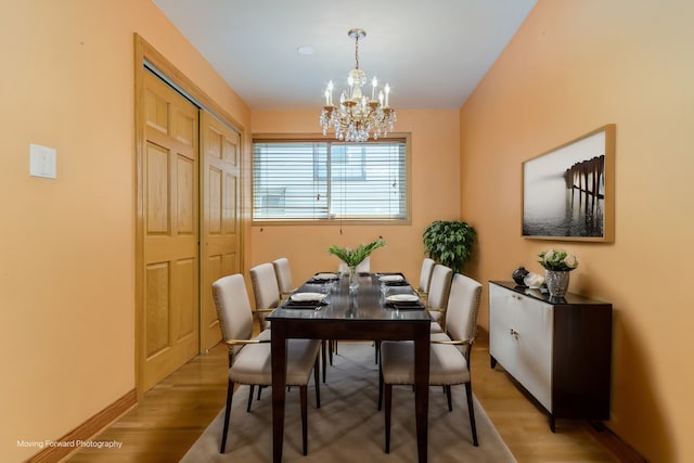 dining space featuring a notable chandelier and light wood-type flooring