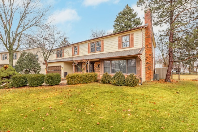 view of front of house featuring a garage, a front yard, brick siding, and a chimney