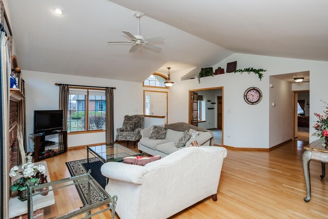 living room with ceiling fan, light hardwood / wood-style flooring, and lofted ceiling