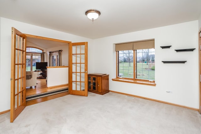 carpeted spare room with french doors