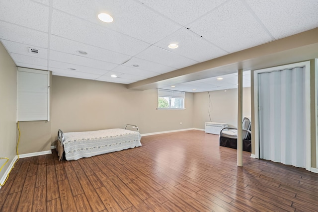 bedroom with a paneled ceiling and hardwood / wood-style flooring