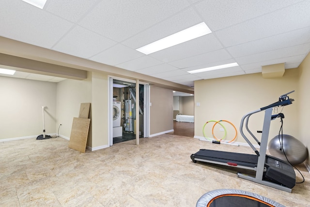 workout area featuring a drop ceiling, gas water heater, and washer / dryer