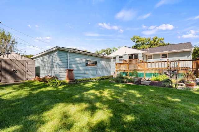 rear view of property featuring a storage unit, a lawn, and a deck