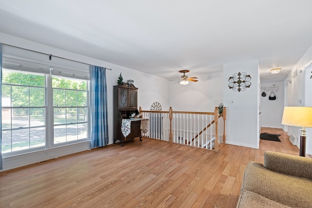 living room with light hardwood / wood-style flooring and ceiling fan