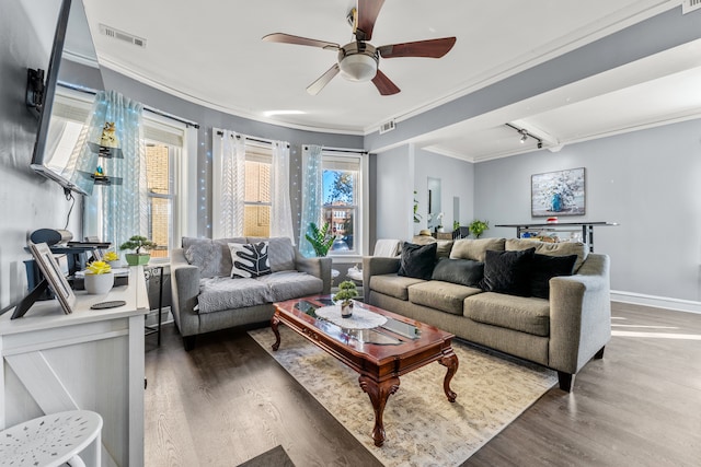 living room with dark wood-type flooring, ceiling fan, and crown molding