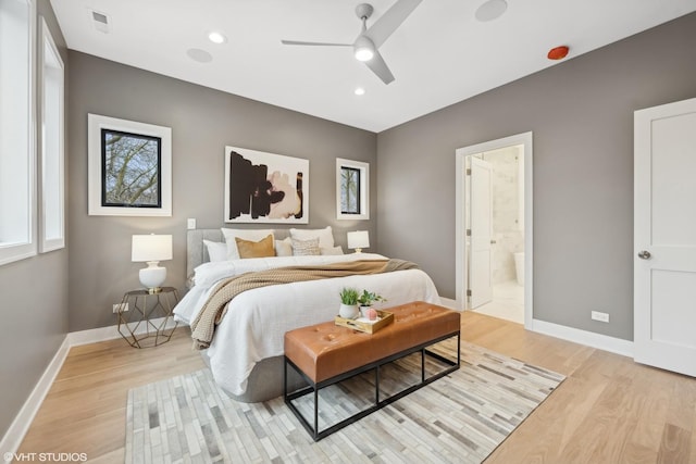 bedroom with ceiling fan, ensuite bathroom, and light hardwood / wood-style floors