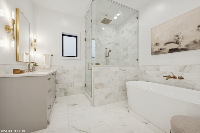 bathroom featuring vanity, shower with separate bathtub, and tile walls