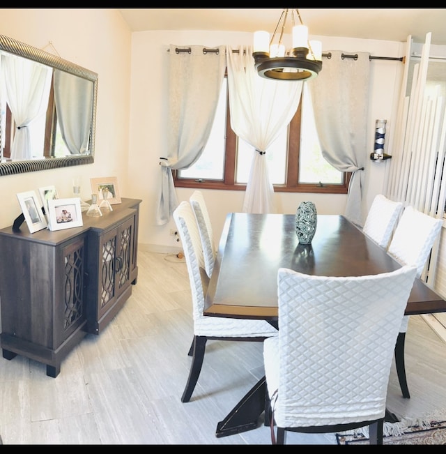 dining space with a chandelier and light hardwood / wood-style flooring