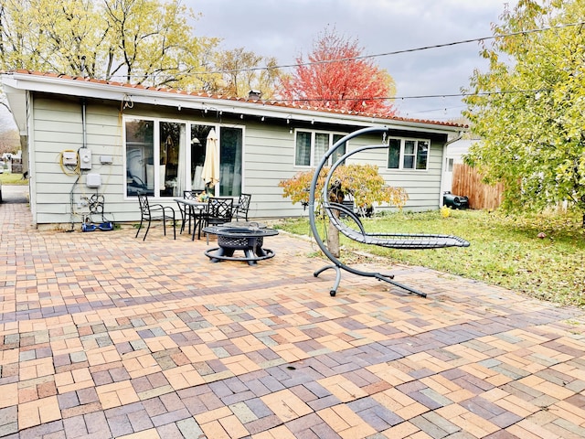 rear view of house featuring a lawn, an outdoor fire pit, and a patio area