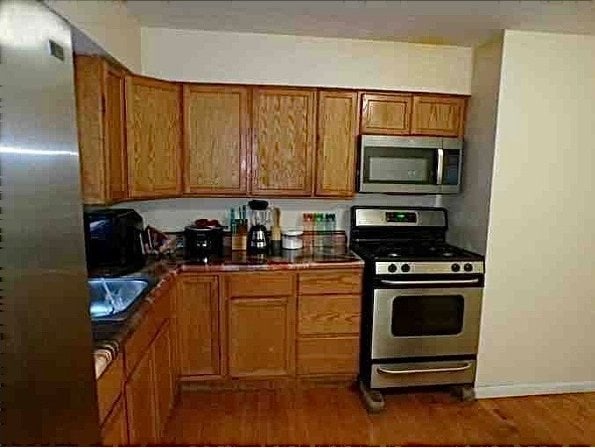 kitchen with dark hardwood / wood-style flooring, sink, and appliances with stainless steel finishes