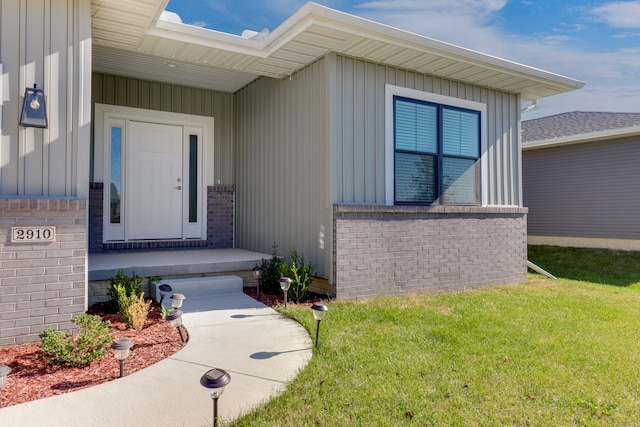 doorway to property with a lawn