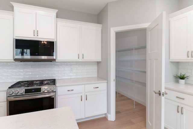 kitchen featuring white cabinetry, appliances with stainless steel finishes, and light hardwood / wood-style flooring