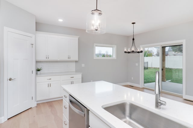 kitchen with decorative backsplash, stainless steel dishwasher, decorative light fixtures, and sink