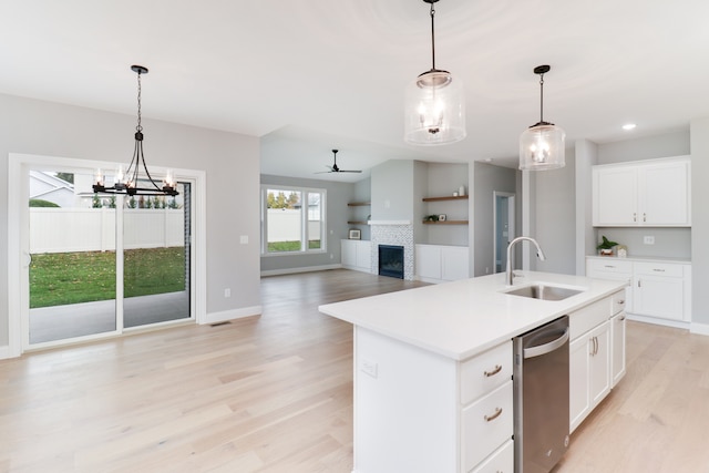 kitchen with white cabinetry, sink, an island with sink, and light wood-type flooring