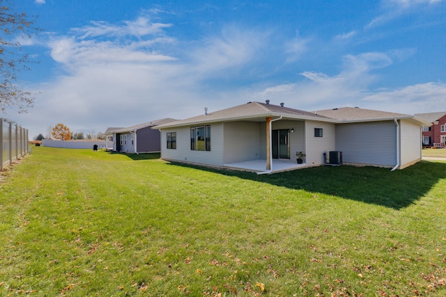 back of house featuring central air condition unit, a patio area, and a yard