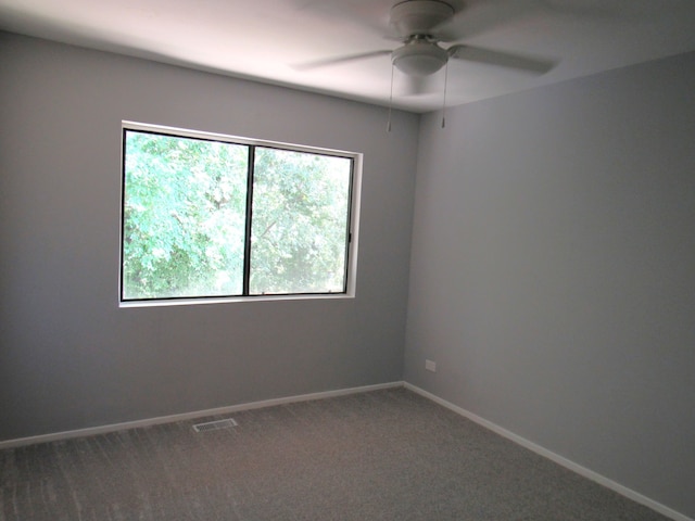 carpeted spare room featuring ceiling fan