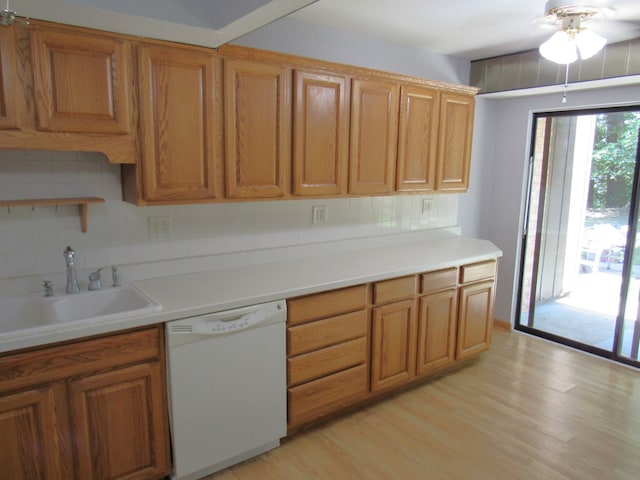 kitchen with tasteful backsplash, sink, dishwasher, ceiling fan, and light hardwood / wood-style flooring