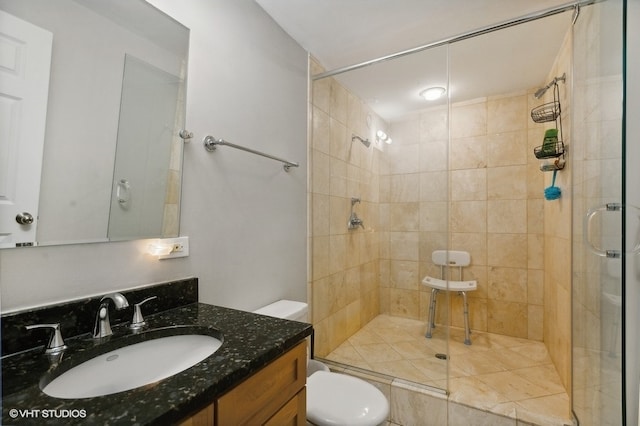 bathroom featuring vanity, toilet, and a shower with shower door