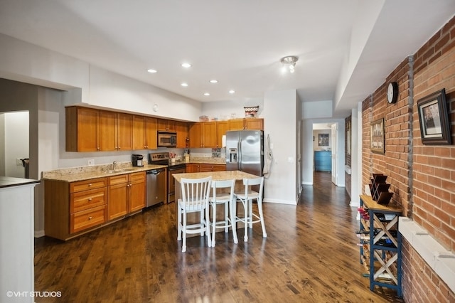 kitchen with a kitchen bar, a center island, stainless steel appliances, and dark wood-type flooring