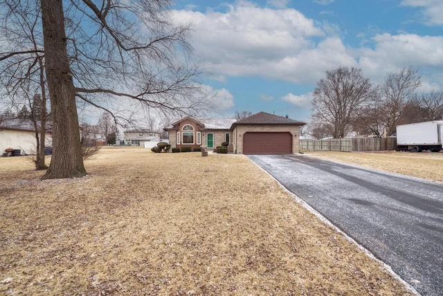 ranch-style house featuring a garage and a front lawn